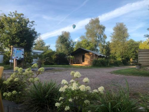 a hot air balloon in the sky over a garden at Glampingtent - Camping Botniahiem - Damwoude-dichtbij Dokkum in Dantumawoude