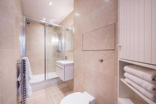 a bathroom with a shower and a toilet and a sink at Fantastic 1 Bedroom Flat Leicester Square West End in London