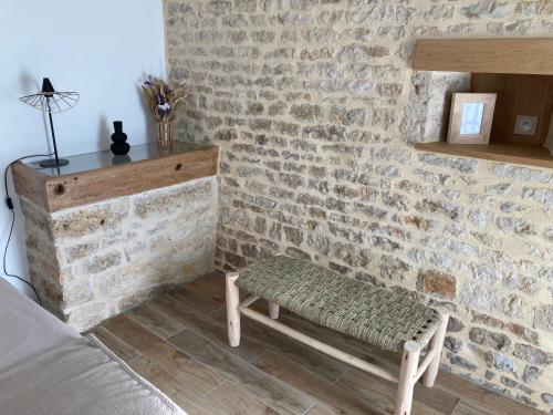 a living room with a brick wall and a bench at Chambre d’hôtes de la Source in Melle