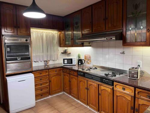 uma cozinha com armários de madeira e electrodomésticos brancos em Valentino House piscina internet parking desayuno em Mendoza