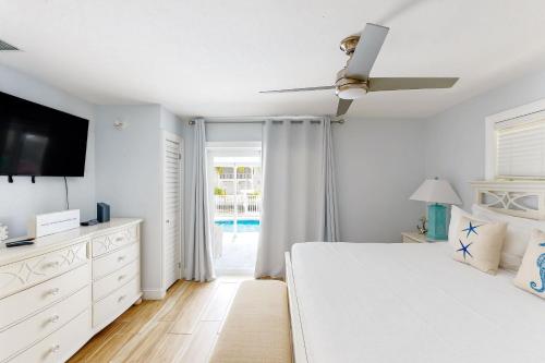 a white bedroom with a bed and a tv at Sunny Bank in Marathon