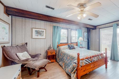 a bedroom with a bed and a chair and a ceiling fan at Drehers Victory in Edisto Island