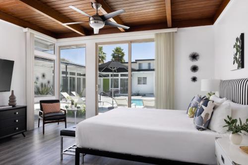 a bedroom with a large white bed and a patio at The Three Fifty Hotel, A Kirkwood Collection Hotel in Palm Springs