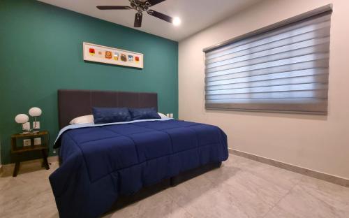a blue bedroom with a bed and a ceiling fan at Palacio Huatulco - 2I in Santa Maria Huatulco