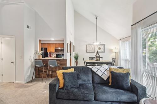 a living room with a couch and a dining room at Overland Park Condo, Close to Lakes and Parks! in Overland Park