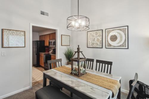 a dining room and kitchen with a table and chairs at Overland Park Condo, Close to Lakes and Parks! in Overland Park