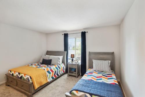 a bedroom with two beds and a window at Overland Park Condo, Close to Lakes and Parks! in Overland Park