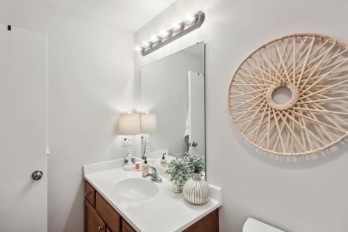 a bathroom with a sink and a mirror at Overland Park Condo, Close to Lakes and Parks! in Overland Park