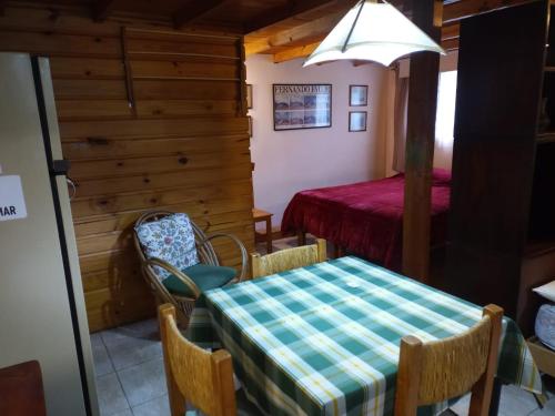 comedor con mesa, sillas y cama en La Casita de Li en San Martín de los Andes