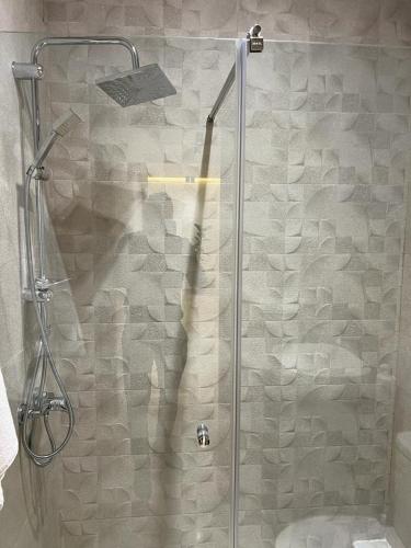 una ducha con puerta de cristal en un baño en Prada appartement Essaouira, en Essaouira