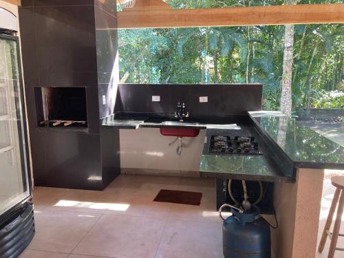 a kitchen with a sink and a counter top at Casa Paraíso - Cond Costa do Sol- Bertioga in Bertioga