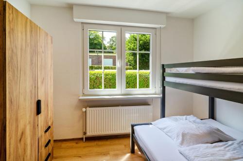 a bedroom with a bunk bed and a window at Ferienhaus Sonnenschein - Wohnung 1 in Norden