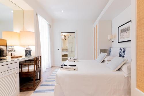 a white bedroom with two beds and a desk at California Park Hotel in Forte dei Marmi