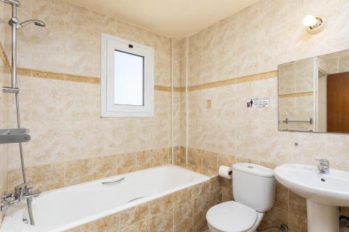 a bathroom with a tub and a toilet and a sink at Villa Kleopatra in Paphos