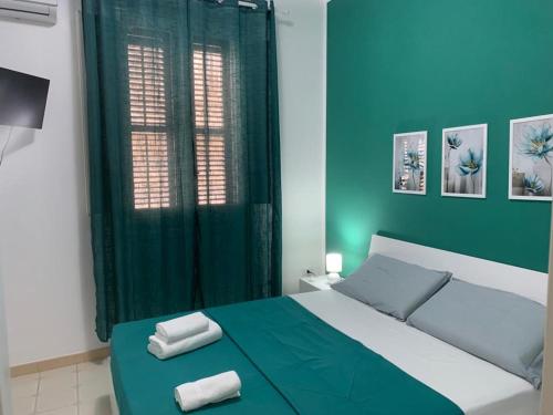 1 dormitorio con 1 cama con 2 toallas en The Apartments Nordino, en Mazara del Vallo