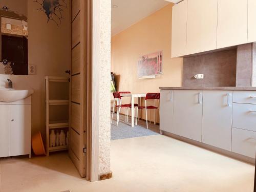 a kitchen with white cabinets and a sink and a table at Comfortable Townhouse in Vilnius