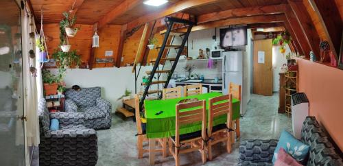 a living room with a green table and a ladder at Paluna cabaña in San Martín de los Andes