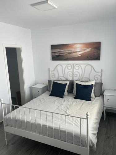 a bedroom with a white bed with blue pillows at MYM in Tías