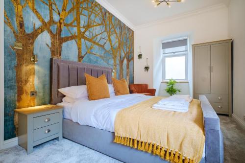 ein Schlafzimmer mit einem Bett mit einem Baumbild an der Wand in der Unterkunft Canon Craig, Luxurious Lakeland stone Cottage in Bowness-on-Windermere