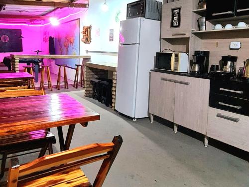a kitchen with a table and a refrigerator at Di Pipa Rooms - Hidromassagem Externa in Pipa