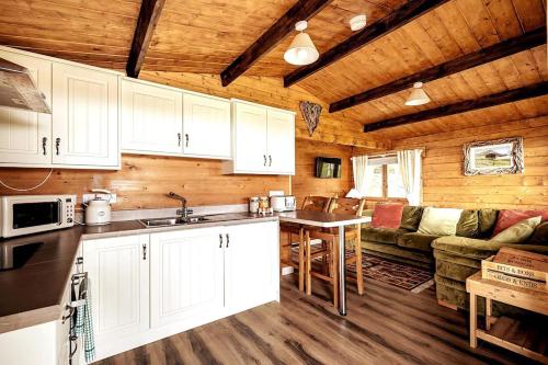 una cucina e un soggiorno in una baita di tronchi di Torr Lodge- luxury log cabin with private hot tub! a Ballycastle