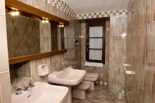 a bathroom with a sink and a toilet and a mirror at Penthouse Cala Gavetta in La Maddalena