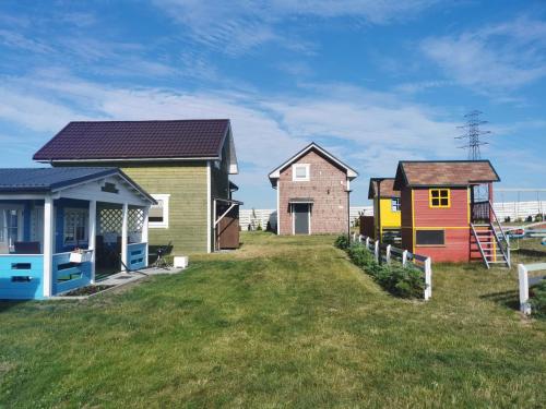 a row of colourful houses on a grass field at Domki u Iwonki - Duży in Niechorze
