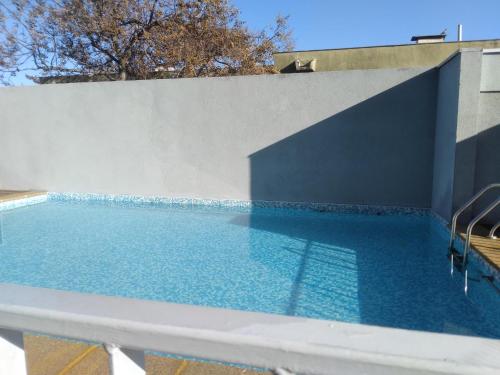 una piscina accanto a un muro bianco di Lindo Depto de 1D mas Estacionamiento en el Centro de la comuna de San Bernardo, Region Metropolitana a Santiago