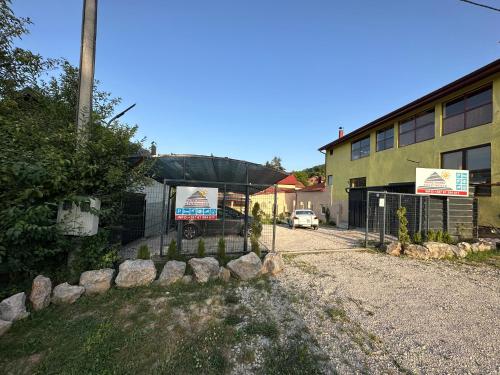 a building with two signs in front of a fence at Ravne Energy Apartments in Visoko