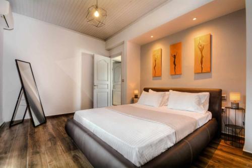una camera da letto con un letto e due dipinti alle pareti di Stratos house! ad Alepoú