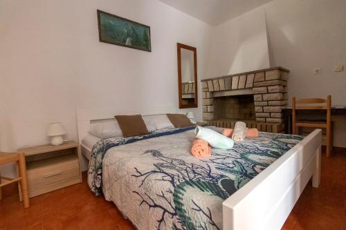 1 dormitorio con 1 cama y chimenea en Fredi, en Mali Lošinj
