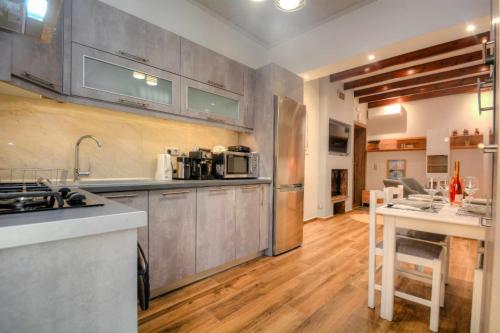 a kitchen with stainless steel appliances and wooden floors at Stratos house! in Alepou
