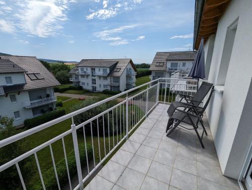 a balcony with a chair and some houses at Luxury Golf Apartment Bad Bellingen 5-9 in Bad Bellingen