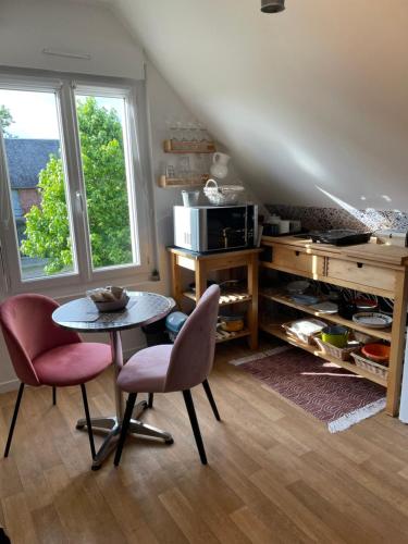 - une cuisine avec une table et deux chaises dans une pièce dans l'établissement Chambre studio de saint-Louis, à Courson