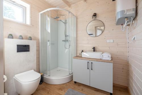 y baño con ducha, aseo y lavamanos. en Natura Jantar - Całoroczne domy drewniane, en Jantar