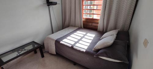 a small bedroom with a bed and a window at Hermoso Apartamento Ubicado en Zona Céntrica de Medellín in Medellín