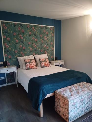 - une chambre avec un grand lit et un mur fleuri dans l'établissement Les Cottages du Chateau de Werde, à Matzenheim