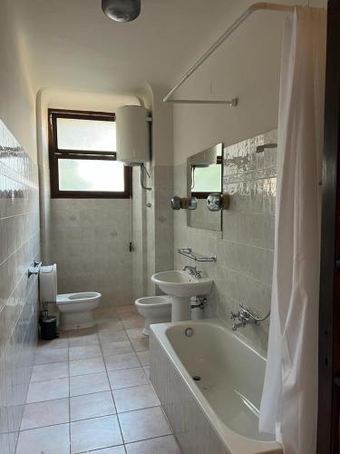 een badkamer met 2 toiletten, een bad en een wastafel bij Terre di siena in Florence