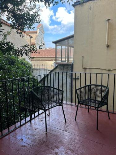 due panche sedute su un patio accanto a una recinzione di Terre di siena a Firenze