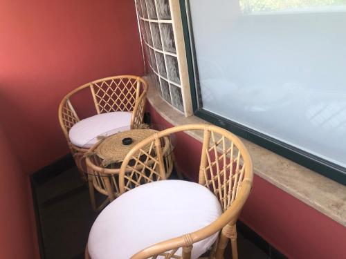 two wicker chairs and a window in a room at Grand Central Apartment LTH in Tirana