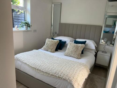 a bedroom with a bed with pillows and a mirror at The Sanctuary in Exmouth