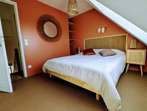 een slaapkamer met een groot bed met een oranje muur bij Duplex au calme avec vue sur les dunes et la mer in Ambleteuse