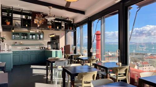 リスボンにあるMonte Belvedere Hotel by Shiaduの市街の景色を望むレストラン(テーブル、椅子付)