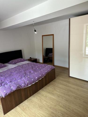 ein Schlafzimmer mit einem Bett mit lilafarbener Bettwäsche in der Unterkunft Casa Niculitel langa Bazilica in Niculiţel