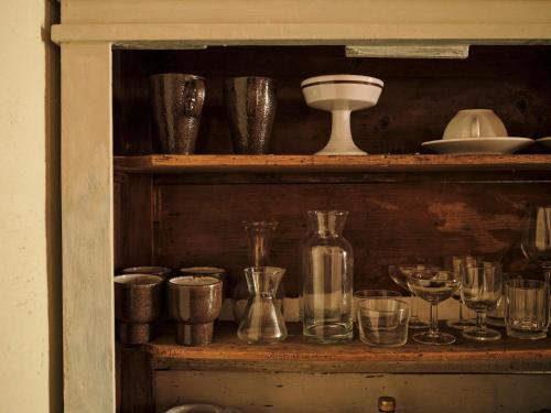 a shelf filled with glasses and wine glasses at La Malvina ~5* centro storico~ Giardinetto privato in Santarcangelo di Romagna