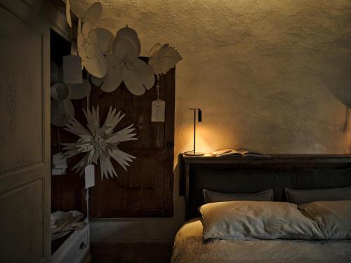 a bedroom with a bed with a flower on the wall at La Malvina ~5* centro storico~ Giardinetto privato in Santarcangelo di Romagna