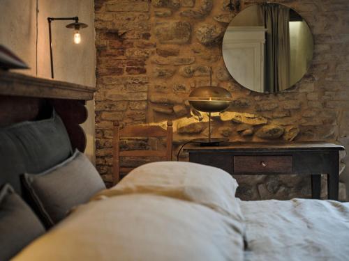 a bedroom with a bed and a mirror and a table at La Malvina ~5* centro storico~ Giardinetto privato in Santarcangelo di Romagna
