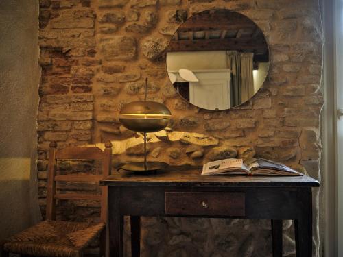 a table with a mirror and a lamp and a book at La Malvina ~5* centro storico~ Giardinetto privato in Santarcangelo di Romagna