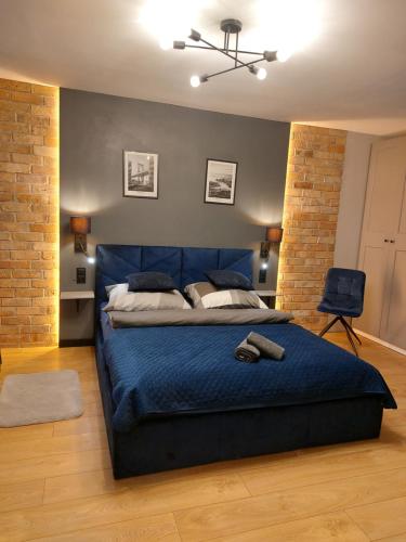 een slaapkamer met een blauw bed en een blauwe deken bij FRIENDS House in Gorzów Wielkopolski