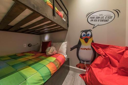 a bedroom with a bunk bed and a stuffed penguin at Hôtel & Suites Normandin Lévis in Lévis